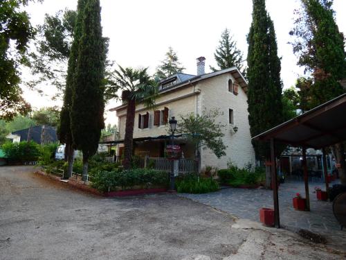 a large white house with trees in front of it at Hotel Rural Camino Medulas in Ponferrada