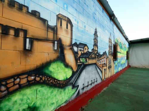 a mural on the side of a building with a painting at Hotel Rural Camino Medulas in Ponferrada