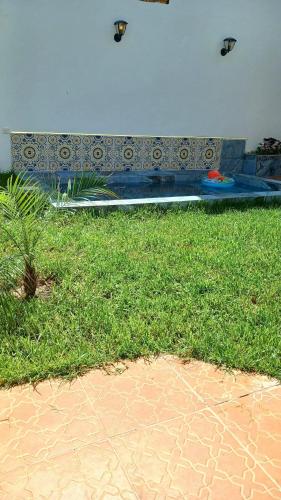 a bench with two kites flying in the air at Maison avec piscine privée sans vis à vis in Martil