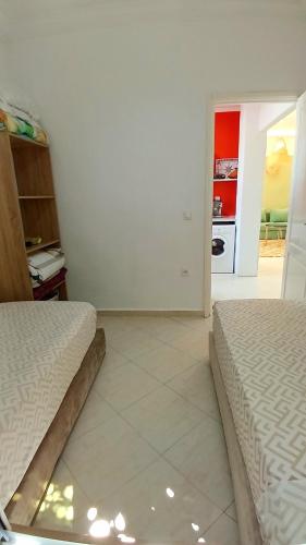 a bedroom with two beds and a kitchen in the background at Maison avec piscine privée sans vis à vis in Martil