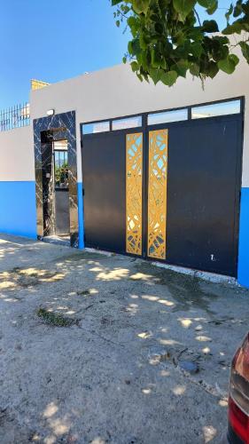 a blue and white building with a gate and a car at Maison avec piscine privée sans vis à vis in Martil