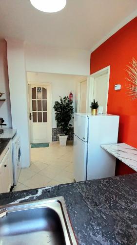 a kitchen with a white refrigerator and red walls at Maison avec piscine privée sans vis à vis in Martil