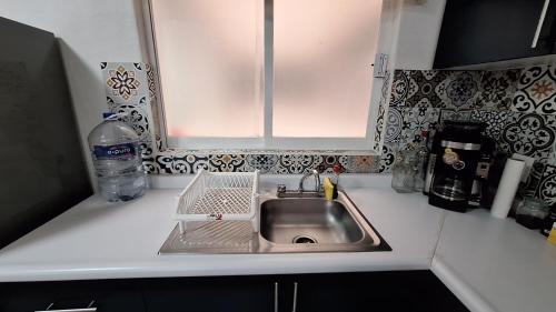 a kitchen counter with a sink and a window at Departamento 5 Min Centro Wifi Elevador in Pátzcuaro