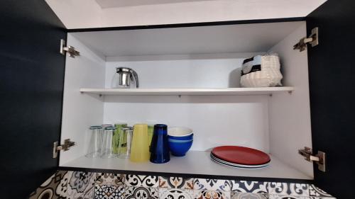 a cupboard with plates and glasses on it at Departamento 5 Min Centro Wifi Elevador in Pátzcuaro