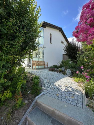 a bench sitting in front of a house with flowers at Apartment Blick Lischana- ein Traum mit Bergpanorama, Sauna, Hottub in Scuol