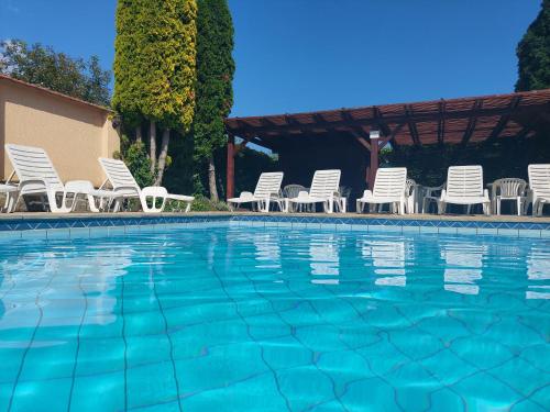 a group of chairs and a swimming pool at Família Apartmanház in Keszthely