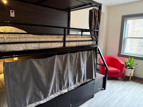 two bunk beds in a room with a red chair at Hostel Fish Seattle in Seattle