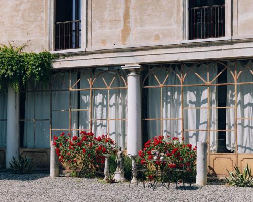 a building with flowers in front of a window at Palazzo Isabella residenza storica in Borgo San Giacomo in Borgo San Giacomo