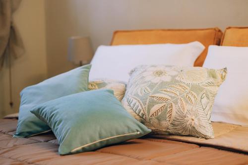 a bed with several pillows on top of it at Palazzo Isabella residenza storica in Borgo San Giacomo in Borgo San Giacomo