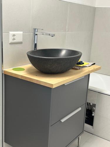 a bathroom with a black bowl sink on a counter at Apartment Blick Lischana- ein Traum mit Bergpanorama, Sauna, Hottub in Scuol