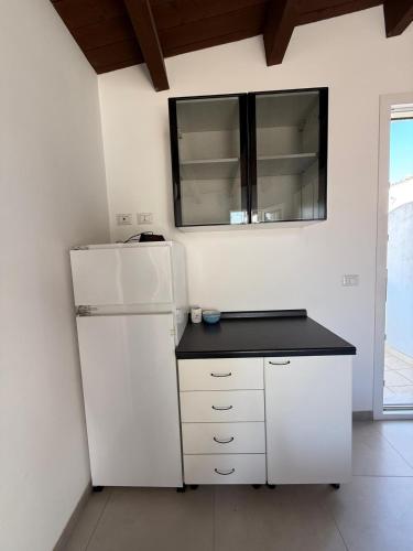 a kitchen with a white refrigerator and a black counter at La casa di Mina in Ruvo di Puglia