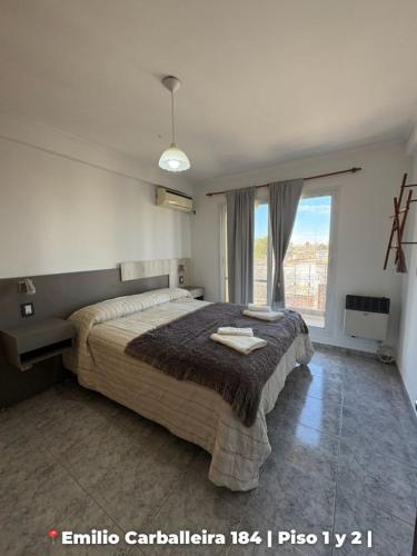a bedroom with a large bed and a window at Departamentos Rufino in Rufino