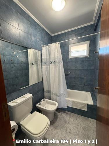 a bathroom with a toilet and a sink and a tub at Departamentos Rufino in Rufino