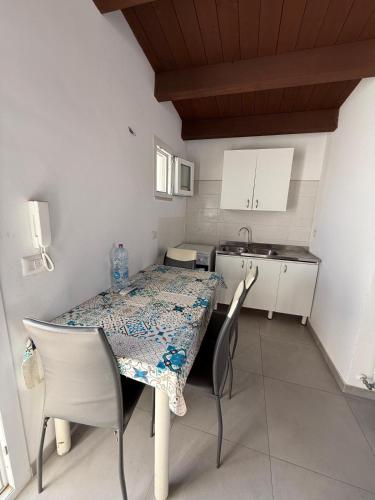 a kitchen with a table and chairs and a kitchen with a table and a table at La casa di Mina in Ruvo di Puglia