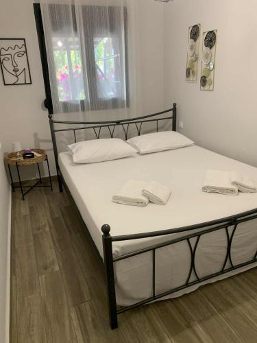 a bed with white sheets and white pillows in a room at Katerina Beach House in Vergia