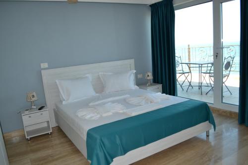 une chambre avec un lit et un balcon avec une table dans l'établissement Le Soleil de Paris, à Eforie Nord