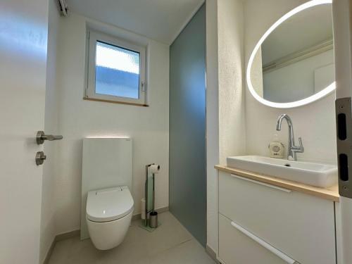 a bathroom with a toilet and a sink and a mirror at Apartment Blick Lischana- ein Traum mit Bergpanorama, Sauna, Hottub in Scuol