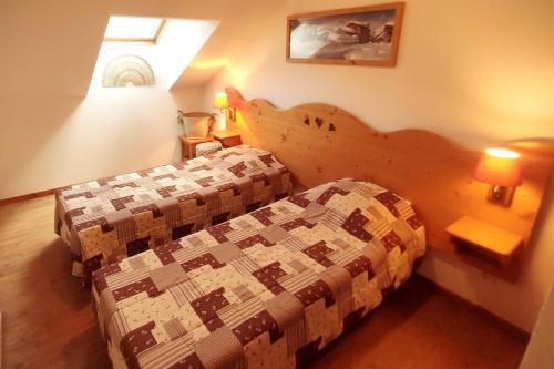 a bedroom with a bed with a quilt on it at Appartement Abries - Jacuzzi et piscine - Pied des pistes - Duplex 6 personnes - Résidence étoilée in Abriès