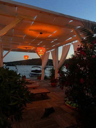 a wooden deck with benches and a pergola at Apartments Antonio in Tisno