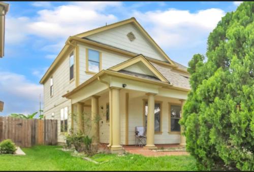 a white house with a porch and a fence at Lux Comfy Home Mins To NW Med Hospital Airport! in Houston