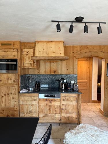 - une cuisine avec des placards en bois et une cuisinière dans l'établissement NEW Appartement CŒUR DU VILLAGE, à Praz-sur-Arly