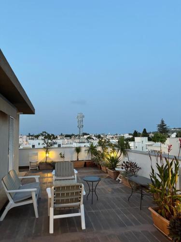 a patio with chairs and tables on a roof at Le Majorelle in La Marsa