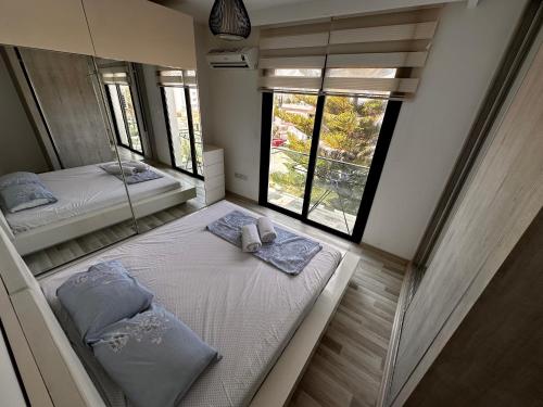two beds in a room with two windows at Kyrenia Central Kaşkar region 2 bedroom residence in Prodhromi