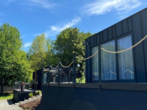 a black house with a fence and windows at rishko resort - Lake View - Private Sauna - free Parking - 24hr Self chceck-in in Holčíkovce