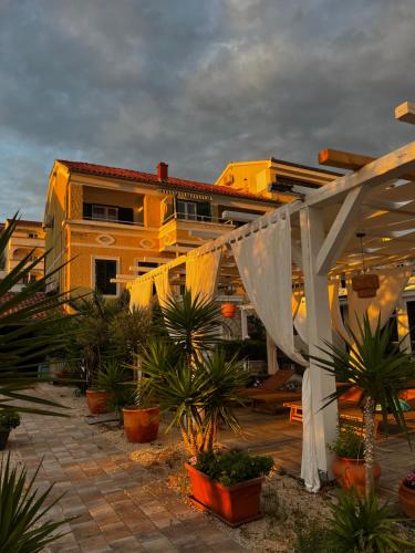 a building with a lot of plants in front of it at Apartments Antonio in Tisno