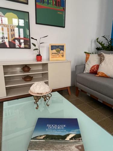 a living room with a couch and a glass table at Studio Sol - 3 min do Mossoró Cidade Junina in Mossoró