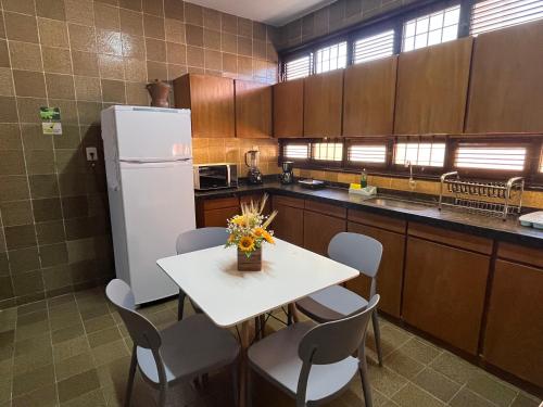 a kitchen with a table and chairs and a refrigerator at Studio Sol - 3 min do Mossoró Cidade Junina in Mossoró