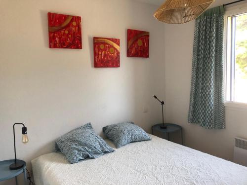 une chambre avec un lit avec deux oreillers dessus dans l'établissement Maison BELLOU à LA FRANQUI, à La Franqui-Plage