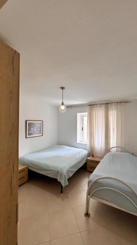 a bedroom with two beds and a window at Bright Apartment 50m from the beach in Himare