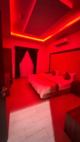 a red room with a bed with a red light at شقق فخامة المسكن للشقق المخدومة in Al Muzāḩimīyah