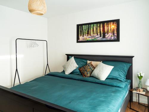 a bedroom with a green bed with a picture on the wall at Flussblick am Töpferberg 8 in Bad Schwartau