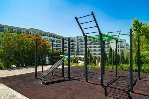 a park with a bench and a ladder at Festa Panorama Hotel in Nesebar