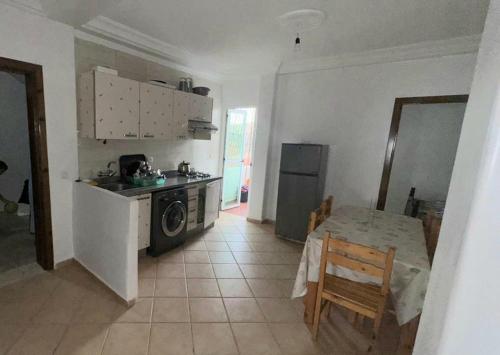 a kitchen with a table and a stove and a microwave at Appartement Oued Laou Mekkad in Oued Laou