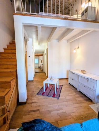 a loft with a staircase and a table in a room at Casa Vacanza OXILIA in Domodossola