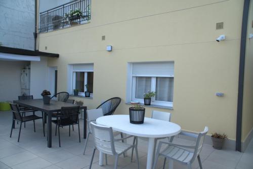 a room with two tables and chairs and windows at Albergue EL CASTILLO in Sarria