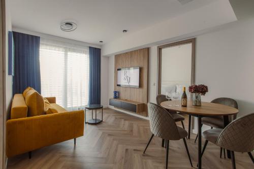 a living room with a yellow couch and a table at R&M Residence in Pécs