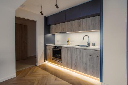 a kitchen with dark wood cabinets and a sink at R&M Residence in Pécs