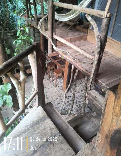 an old wooden stairwell with a ladder and a chair at Sierra Tayrona hostel in El Zaino