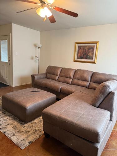 a living room with a brown leather couch and ottoman at Temora Loop in Killeen