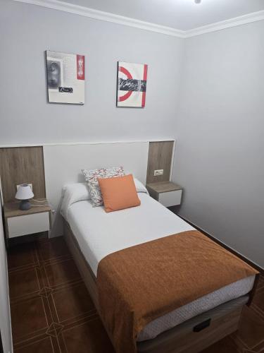 a small bedroom with a bed and two night stands at A CARAMIÑA in Camariñas