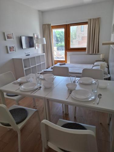 a dining room with a table with dishes on it at Família Apartmanház in Keszthely