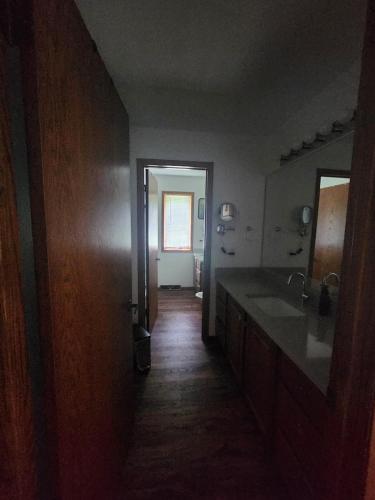 a hallway of a bathroom with a sink and a mirror at Whispering Woods Estate - Relax, Recharge, Connect - 12 wooded acres, 3 Bedrooms, 3 Baths, sleeps 10 in Rockton
