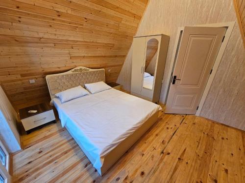 a bedroom with a bed in a wooden room at Aframe new asm in Gabala