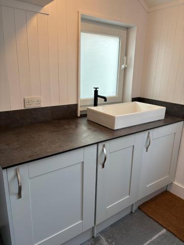 a bathroom counter with a sink and a mirror at Horseshoe Cottage Edwinstowe in Edwinstowe