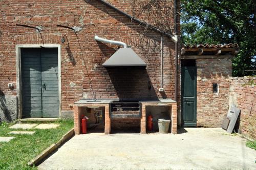 a brick building with an outdoor oven in a courtyard at Cascina Coccione in Predosa