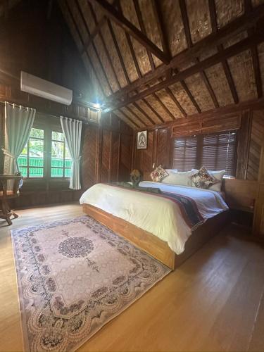 a bedroom with a large bed with a rug at Beehive Cottages in Amed